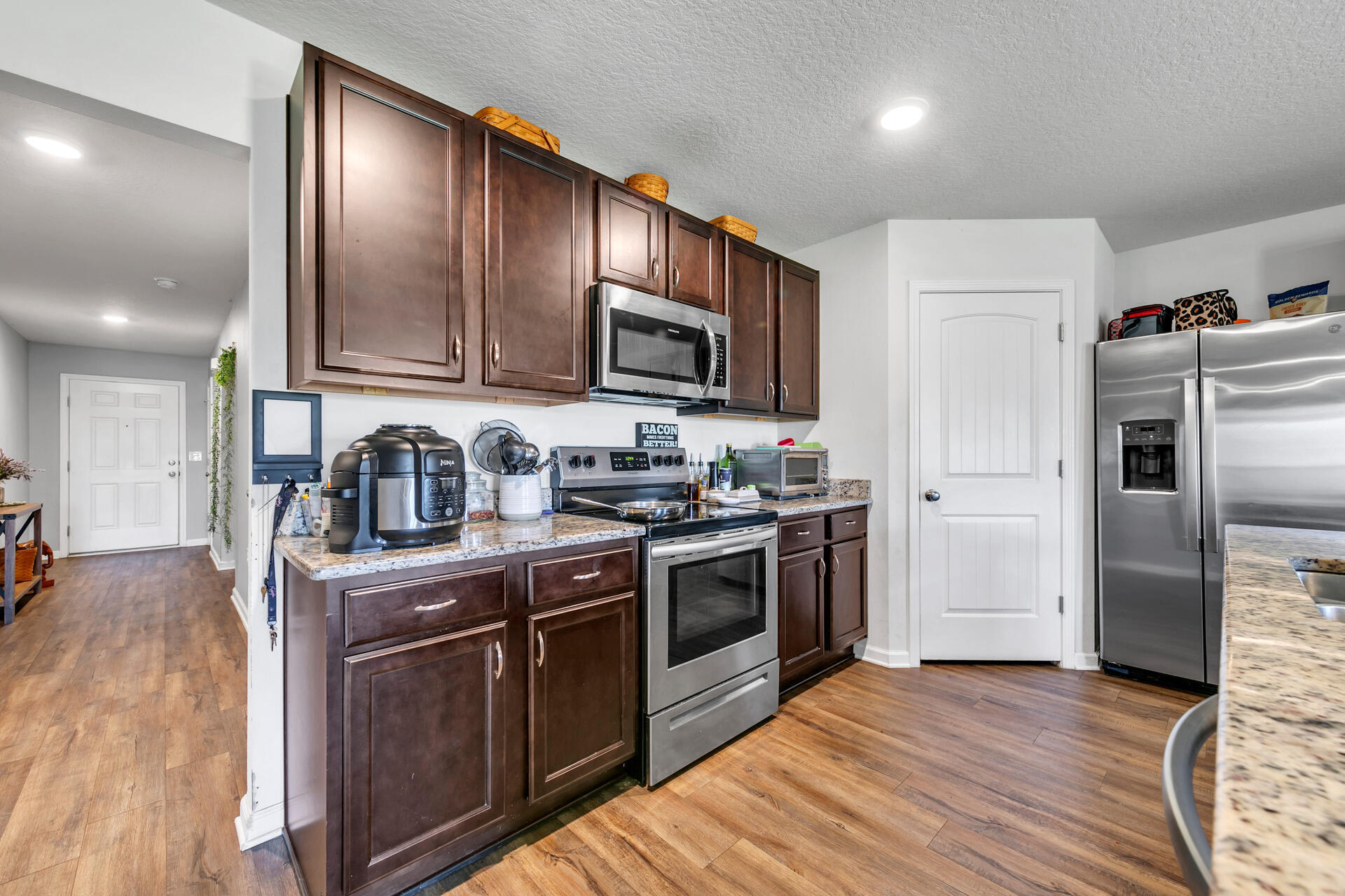 507 Merganser Way Crestview, FL 32539 - Photo 18 of 45 a kitchen with granite countertop wooden floors stainless steel appliances and a sink
