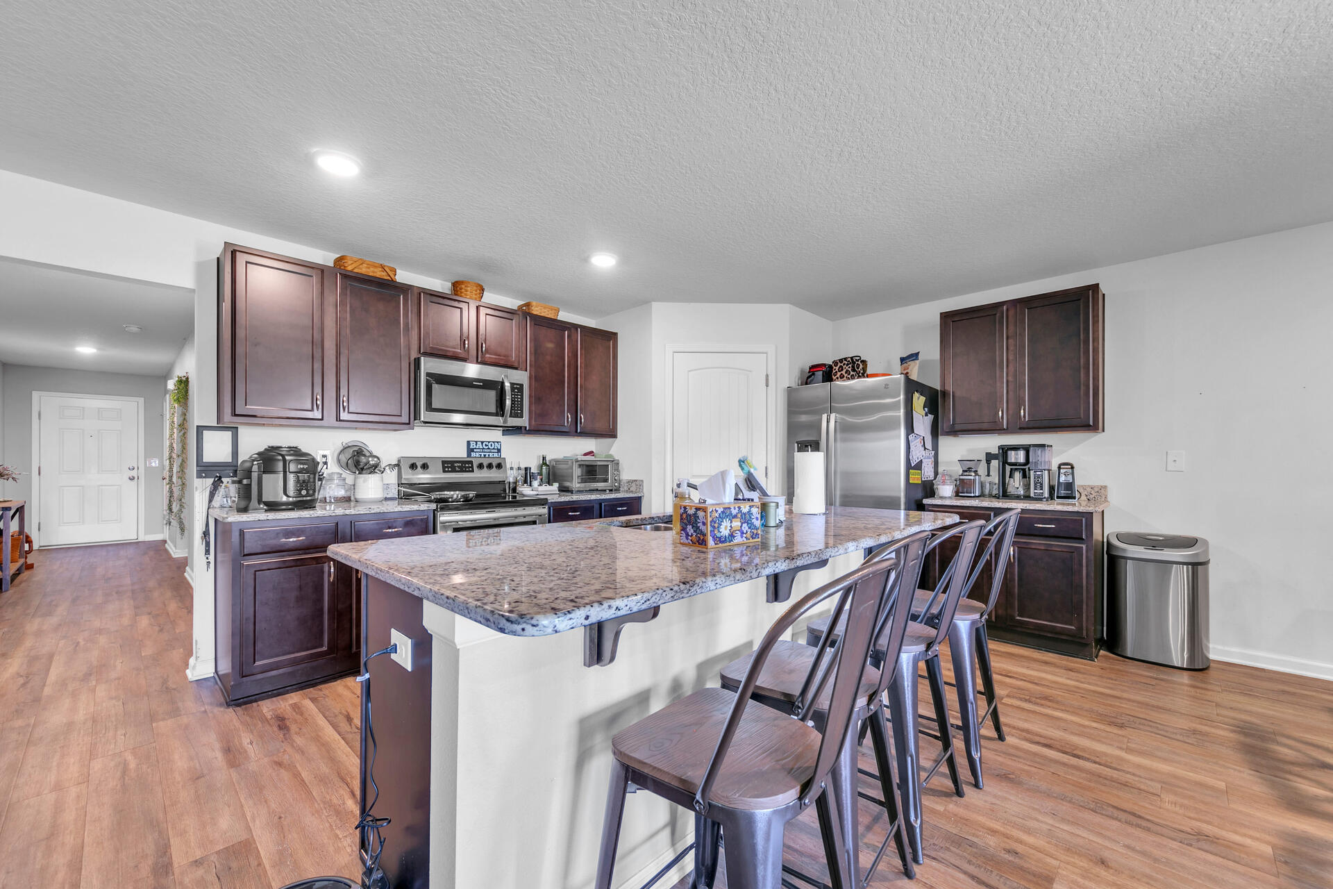 507 Merganser Way Crestview, FL 32539 - Photo 19 of 45 a kitchen with stainless steel appliances granite countertop a stove top oven a sink dishwasher a dining table and chairs with wooden floor