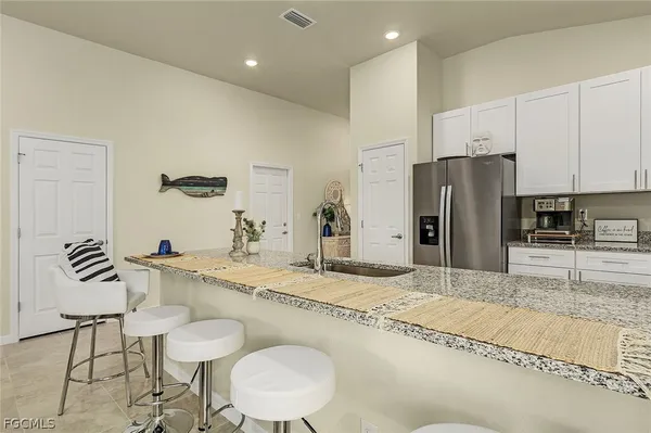 a kitchen with stainless steel appliances granite countertop a sink and a refrigerator