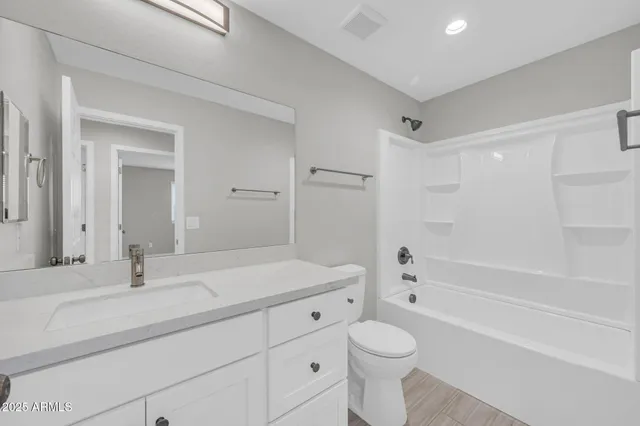 a bathroom with a sink a toilet and a large mirror