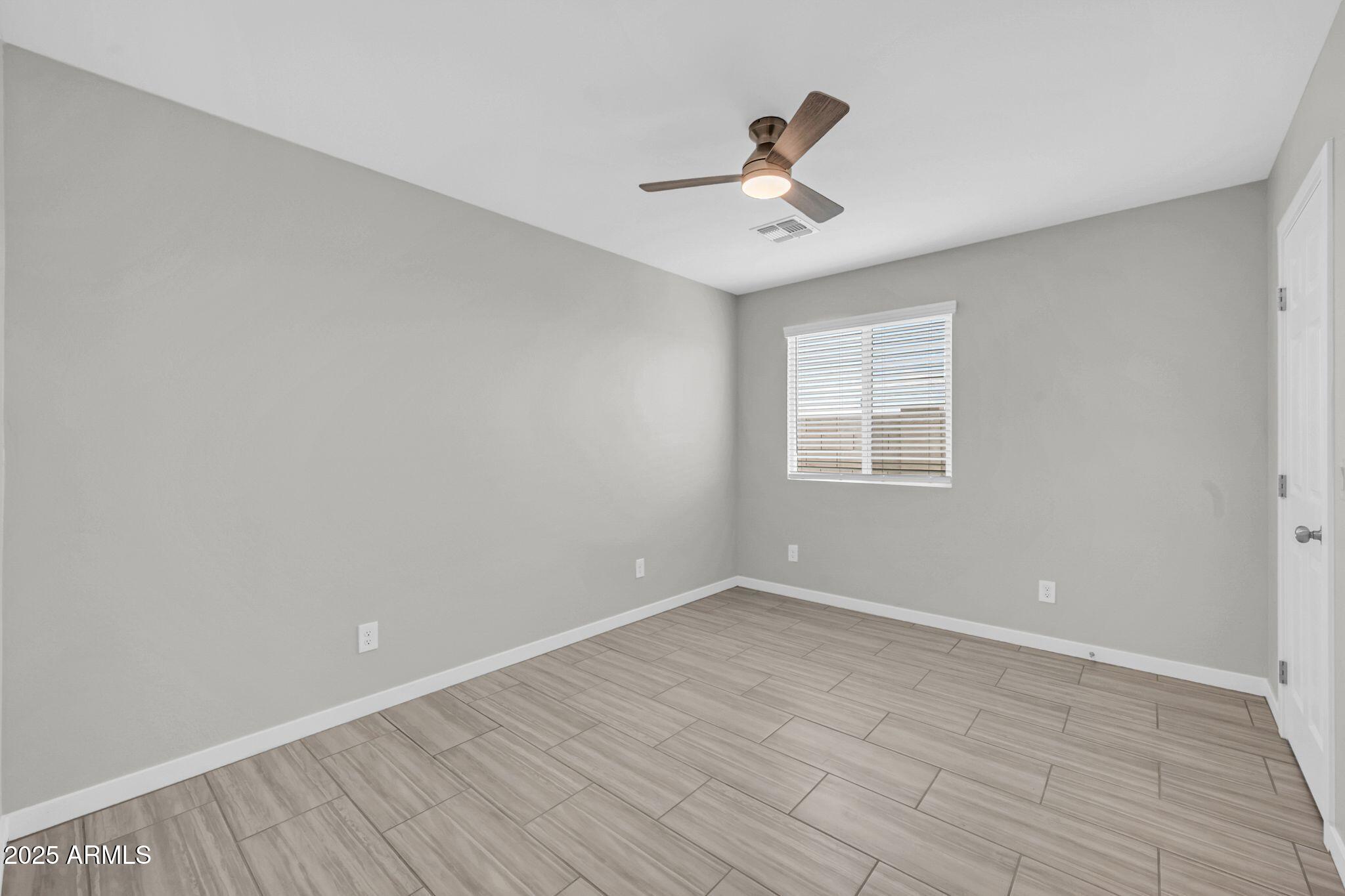 13215 South Laredo Road Arizona City, AZ 85123 - Photo 24 of 31 a view of an empty room with wooden floor and a window