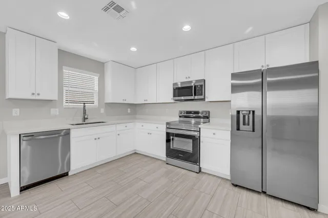 a kitchen with kitchen island granite countertop stainless steel appliances cabinets a sink and a center island