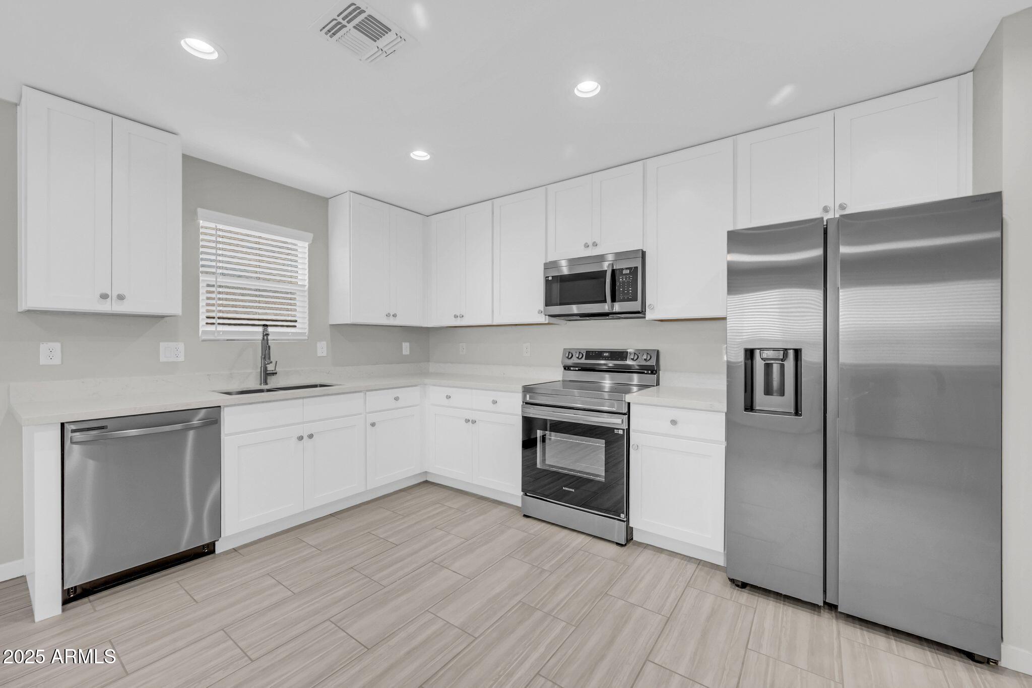13215 South Laredo Road Arizona City, AZ 85123 - Photo 4 of 31 a kitchen with kitchen island granite countertop stainless steel appliances cabinets a sink and a center island