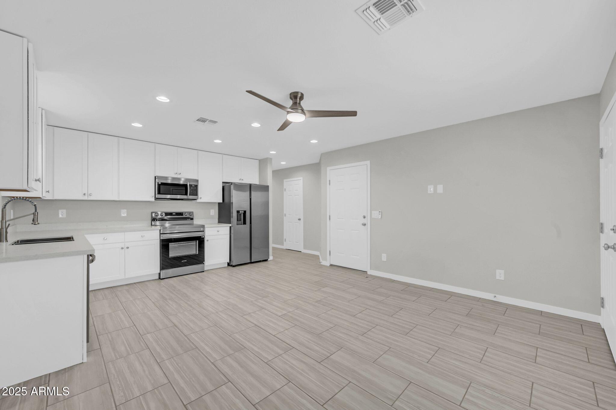13215 South Laredo Road Arizona City, AZ 85123 - Photo 6 of 31 a view of kitchen with stainless steel appliances refrigerator stove microwave and cabinets