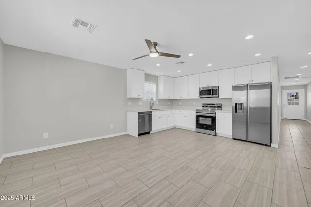 a kitchen with stainless steel appliances a refrigerator sink and cabinets