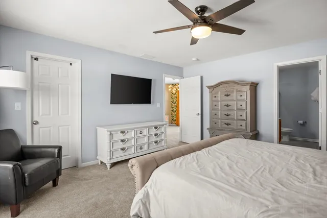 a bedroom with a bed a couch and a flat screen tv