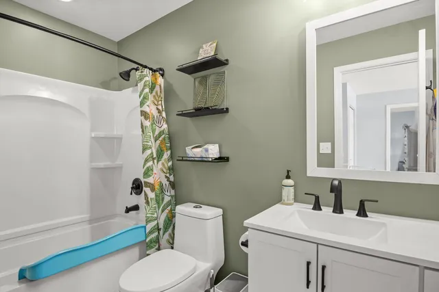 a bathroom with a sink a toilet and shower curtain