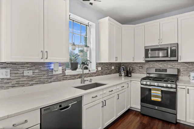 a kitchen with appliances a sink and cabinets