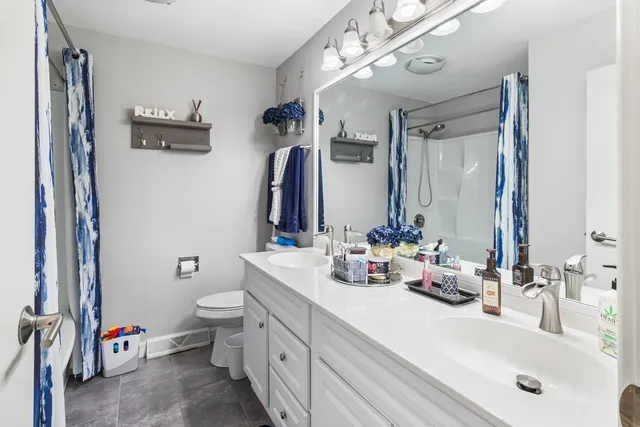 a bathroom with a double vanity sink mirror and toilet