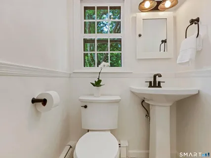 a bathroom with a sink a toilet and a mirror