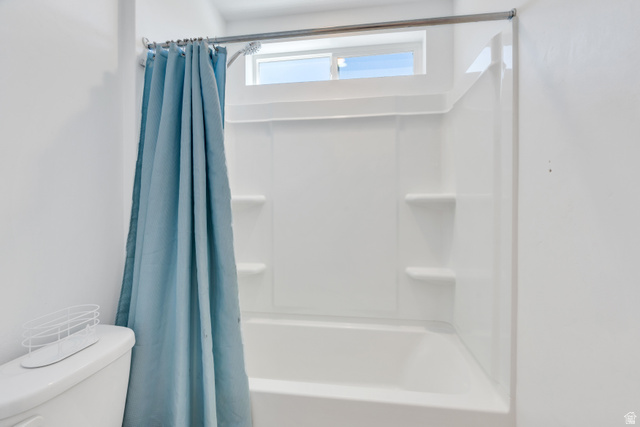 646 South Meade Street Mapleton, UT 84664 - Photo 19 of 46 Bathtub and shower combination featuring a white surround with built-in shelving, a chrome shower rod, and an overhead window