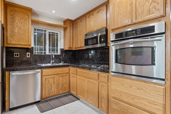 a kitchen with granite countertop cabinets stainless steel appliances and a sink