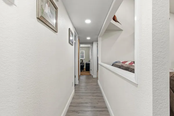 a view of a hallway with wooden floor and staircase