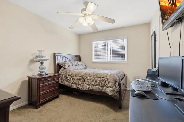 a bedroom with a bed and a flat tv screen on a dresser