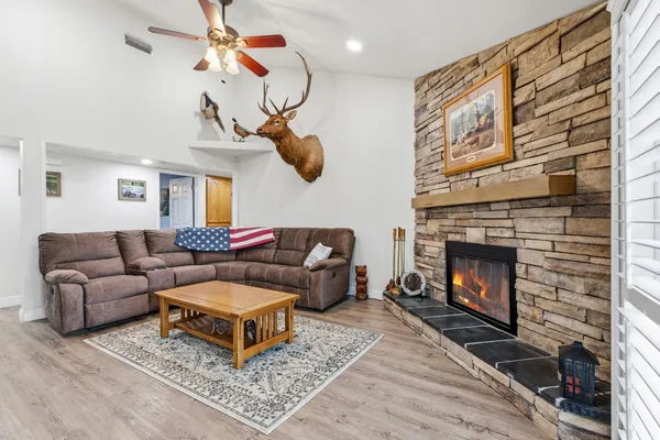 a living room with furniture a flat screen tv and a fireplace