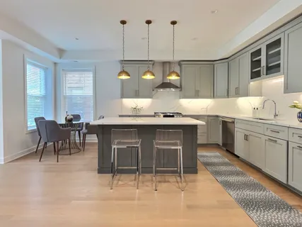 a kitchen with a sink a counter space appliances and cabinets