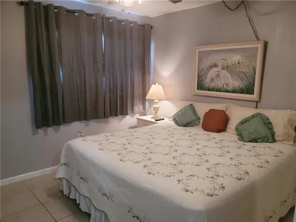 a bedroom with a bed and a painting on the wall