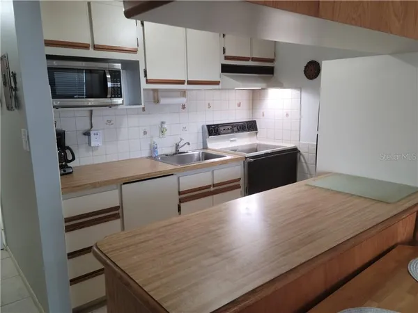 a kitchen with stainless steel appliances granite countertop a sink stove and microwave