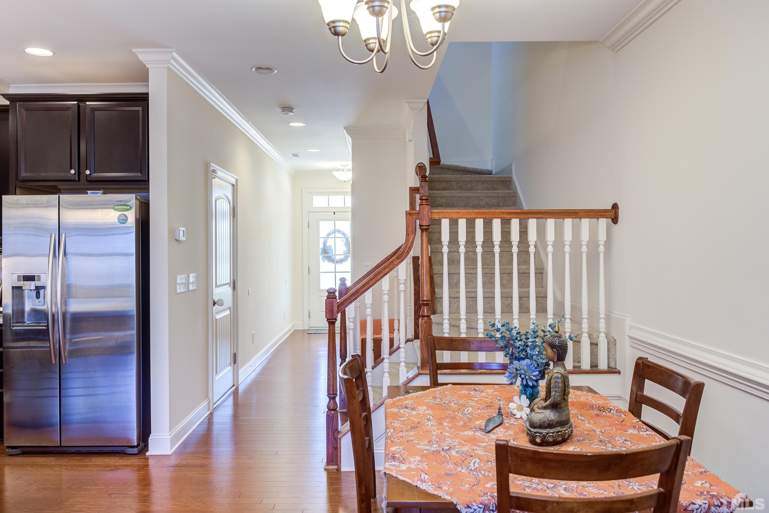449 Talons Rest Way Cary, NC 27513 - Photo 10 of 54 a view of a dining room with furniture a chandelier and wooden floor