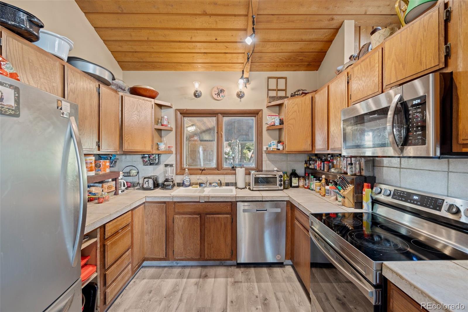 450 East Happy Canyon Road Castle Rock, CO 80108 - Photo 32 of 48 a kitchen with a sink a stove and cabinets