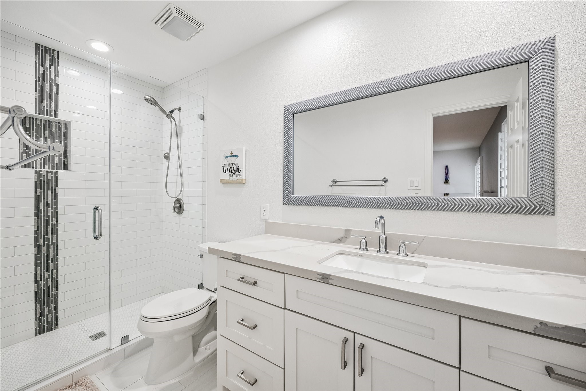 15 West Beckonvale Circle The Woodlands, TX 77382 - Photo 29 of 44 The secondary en-suite bathroom features quartz countertops, a large framed mirror, generous storage space, and a walk-in spacious shower.