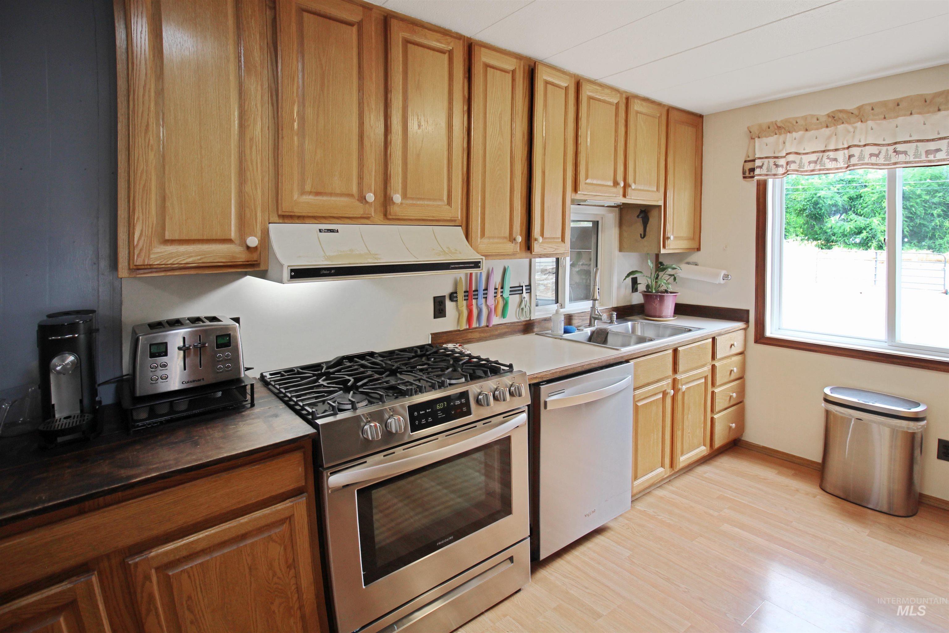 1265 Pioneer Road Weiser, ID 83672 - Photo 10 of 29 Kitchen featuring wood-finish flooring, natural wood cabinetry, and a stainless steel gas range with matching oven