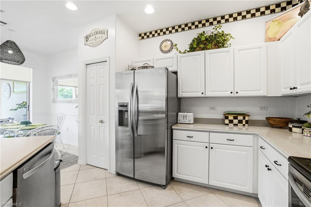 8430 Radcliffe Terrace, Unit 202 Naples, FL 34120 - Photo 11 of 37 a kitchen with a refrigerator a sink and cabinets