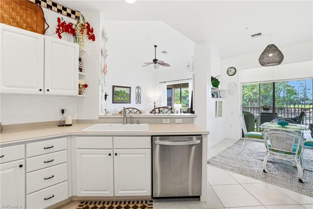 8430 Radcliffe Terrace, Unit 202 Naples, FL 34120 - Photo 12 of 37 White cabinetry, light countertops, stainless steel appliances, ample storage, and a breakfast bar for casual dining.