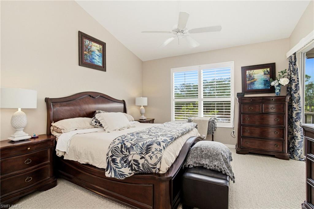 8430 Radcliffe Terrace, Unit 202 Naples, FL 34120 - Photo 17 of 37 a bedroom with a bed and a chandelier