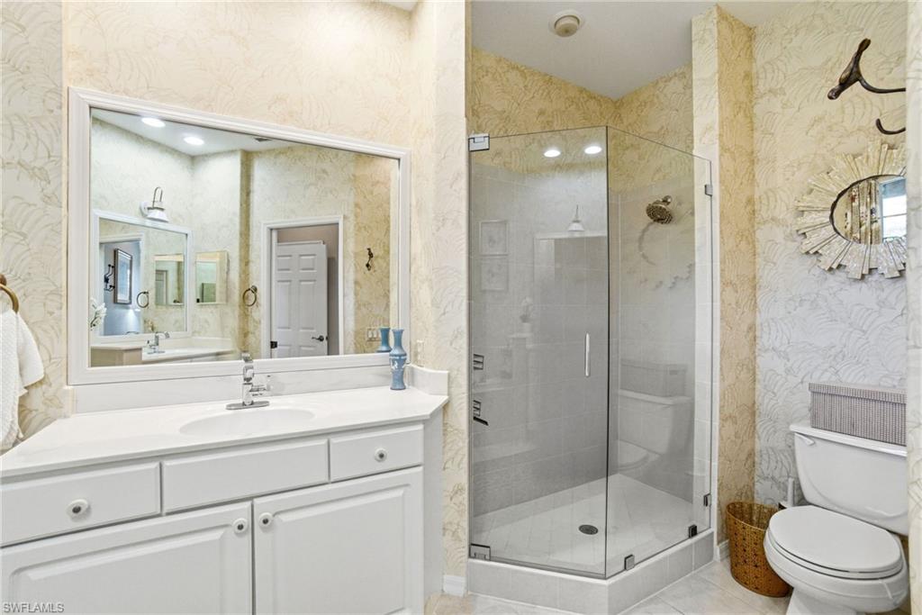 8430 Radcliffe Terrace, Unit 202 Naples, FL 34120 - Photo 20 of 37 a bathroom with a shower sink vanity mirror and toilet