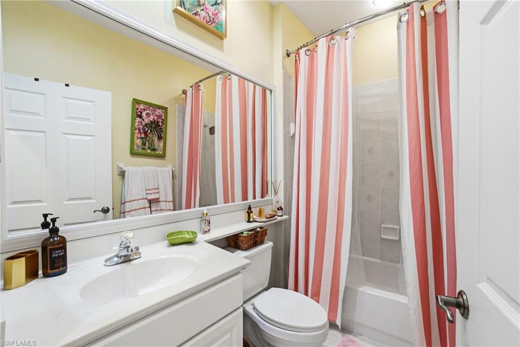 8430 Radcliffe Terrace, Unit 202 Naples, FL 34120 - Photo 22 of 37 a bathroom with a sink a toilet and shower curtain