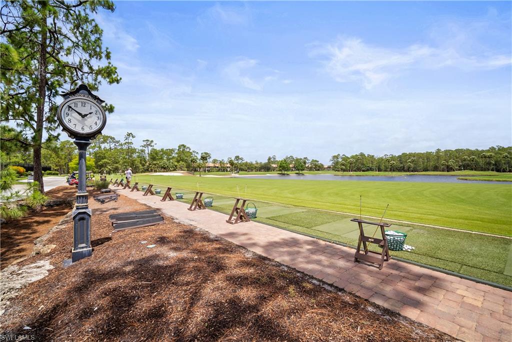 8430 Radcliffe Terrace, Unit 202 Naples, FL 34120 - Photo 28 of 37 a view of a lake with a table and chairs next to a lake