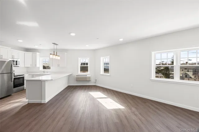 a large white kitchen with wooden floors and white walls
