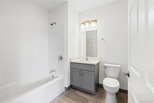 a bathroom with a granite countertop toilet a sink and bathtub