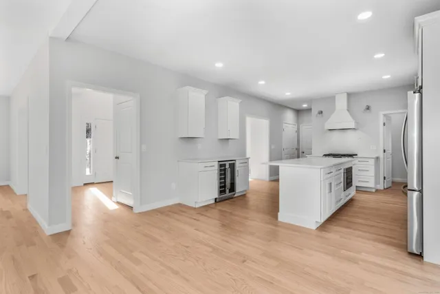 a large kitchen with a large counter top a sink stainless steel appliances and cabinets