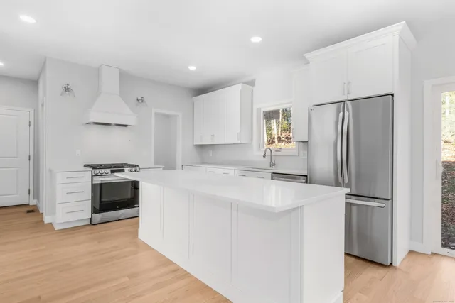 a kitchen with stainless steel appliances white cabinets and a refrigerator