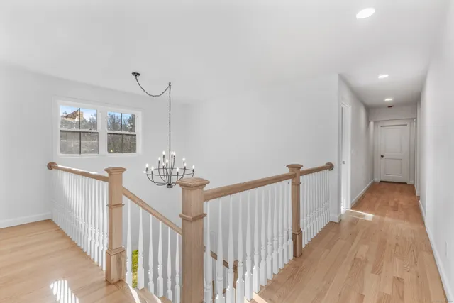 a view of a hallway view with wooden floor and staircase