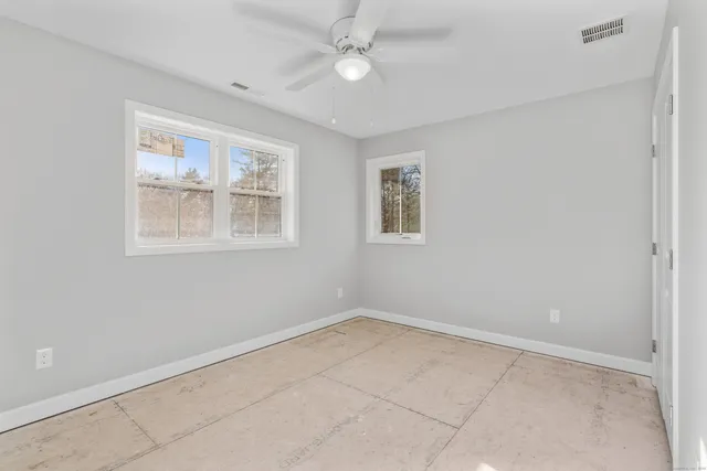 an empty room with windows and closet