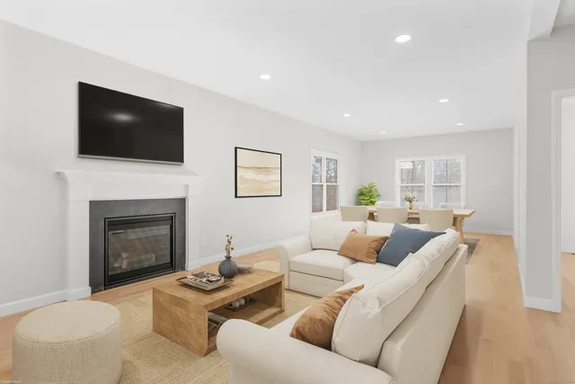 a living room with furniture a flat screen tv and a fireplace