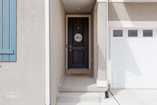 540 Lefty Lane Tooele, UT 84074 - Photo 4 of 48 Doorway to property with a garage and stucco siding