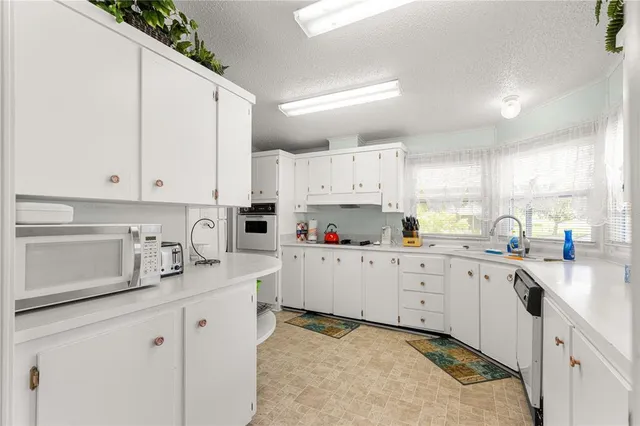 a kitchen with cabinets appliances a sink and a counter top space