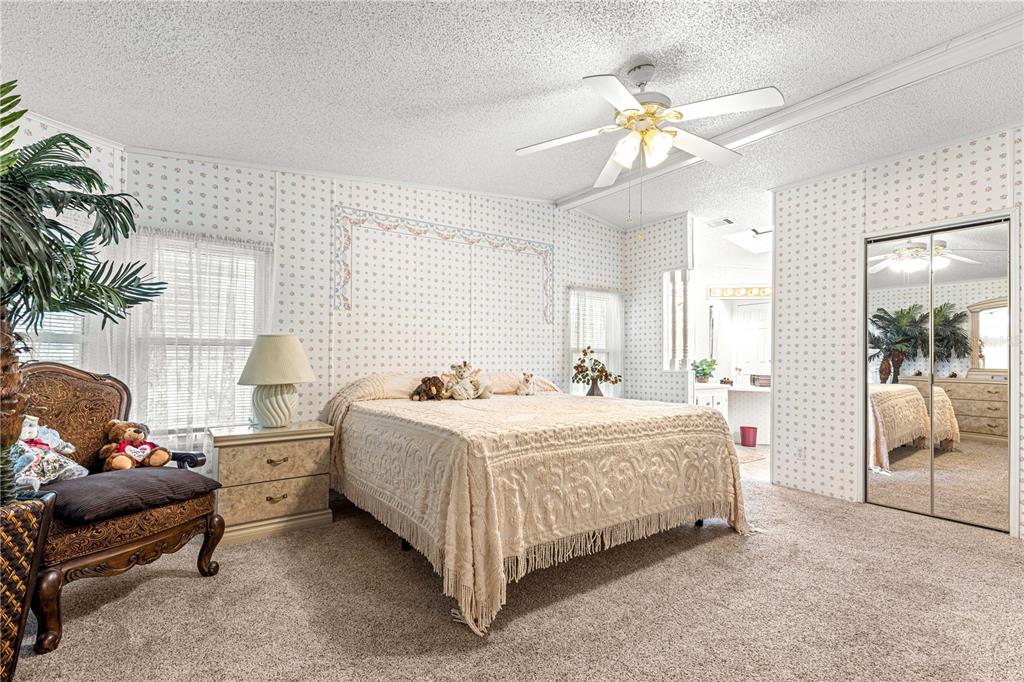 13081 Southeast 47th Court Belleview, FL 34420 - Photo 20 of 42 a bedroom with a bed and a chandelier