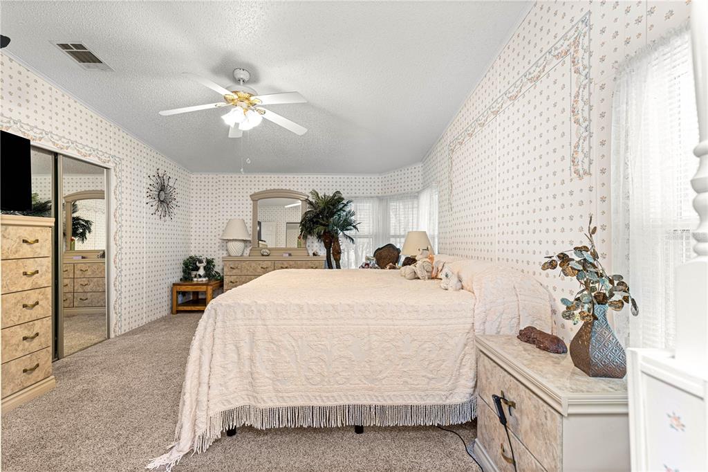 13081 Southeast 47th Court Belleview, FL 34420 - Photo 22 of 42 a bedroom with a bed and ceiling fan