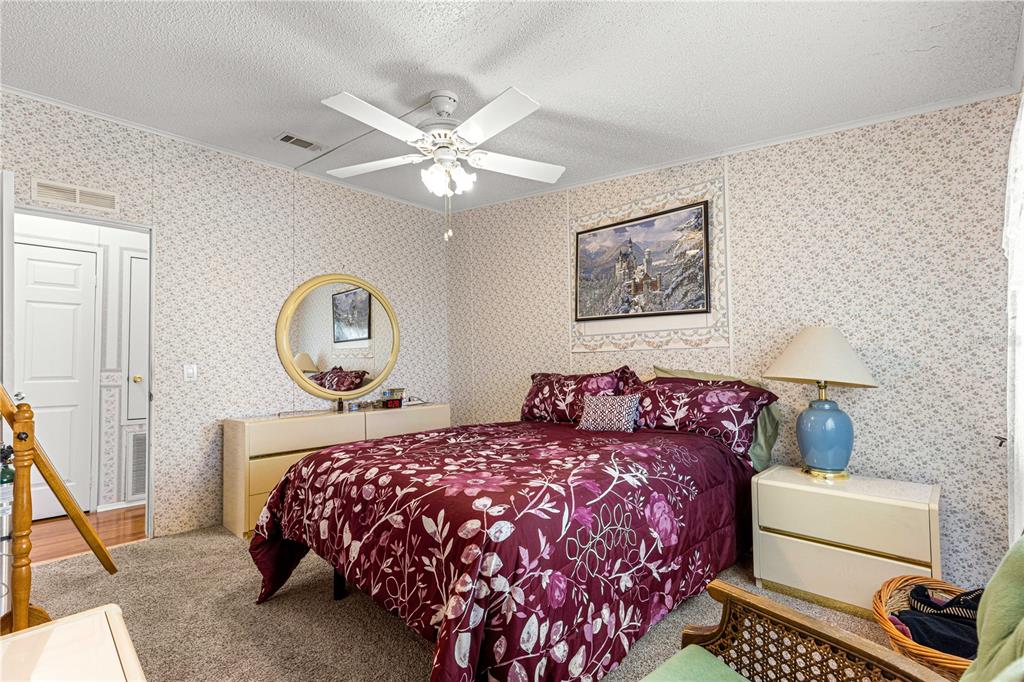 13081 Southeast 47th Court Belleview, FL 34420 - Photo 29 of 42 a bedroom with a bed and a chandelier