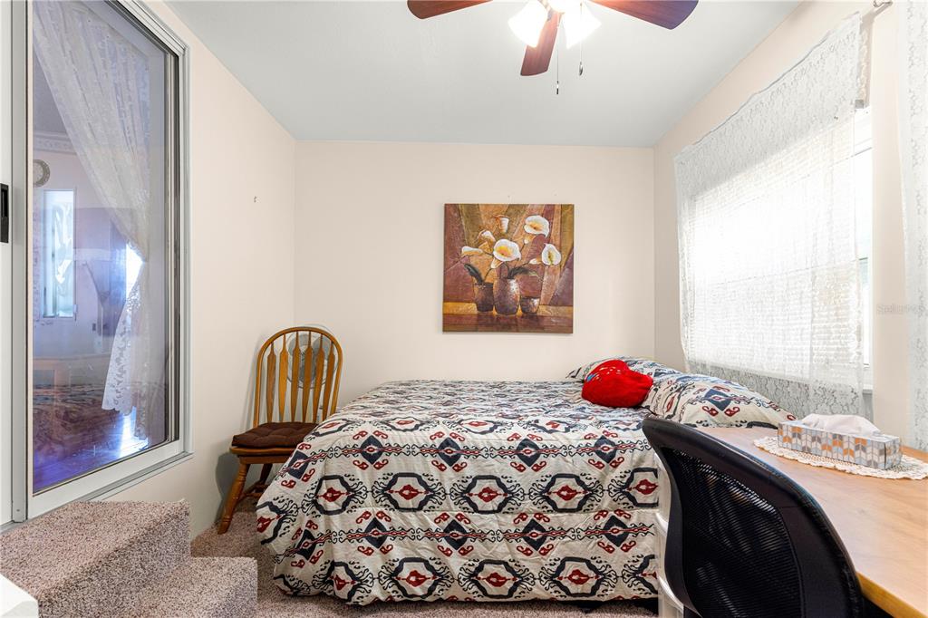 13081 Southeast 47th Court Belleview, FL 34420 - Photo 31 of 42 a bedroom with a bed and a chandelier