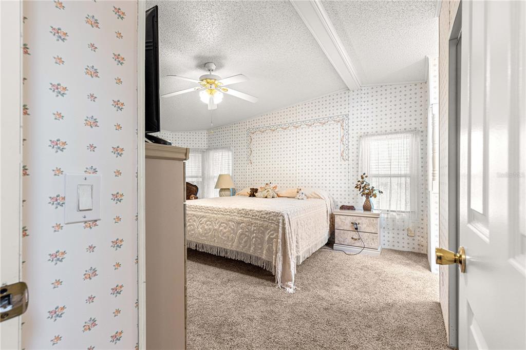 13081 Southeast 47th Court Belleview, FL 34420 - Photo 33 of 42 a room with a bed and a chandelier