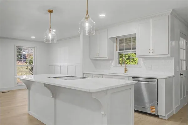 a kitchen with stainless steel appliances sinks a chandelier and view living room