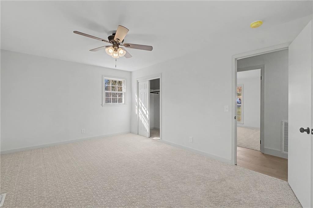 115 Devonwood Drive Calhoun, GA 30701 - Photo 16 of 35 an empty room with windows and fan chandelier