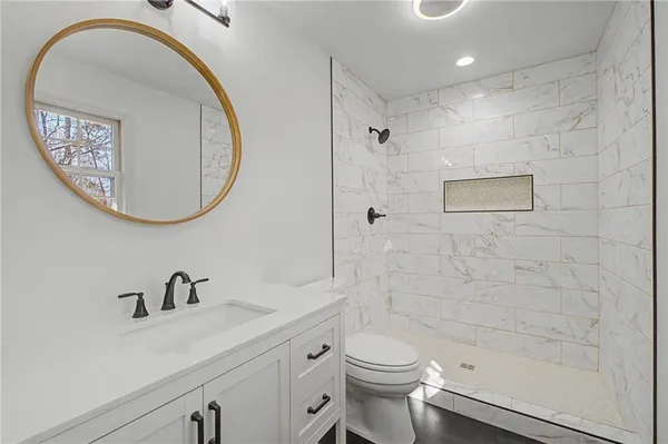 a bathroom with a toilet sink and mirror