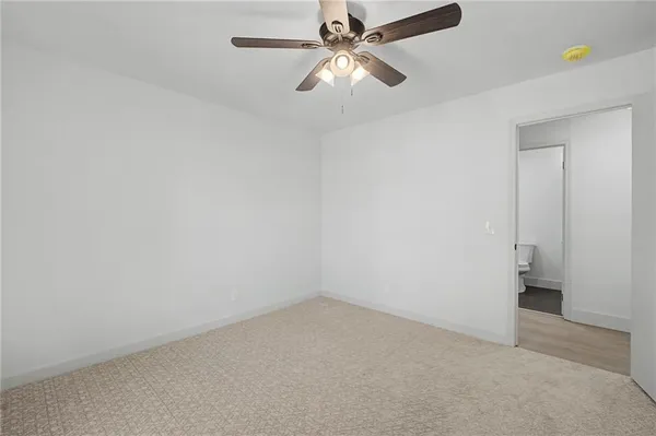 an empty room with a ceiling fan and a window